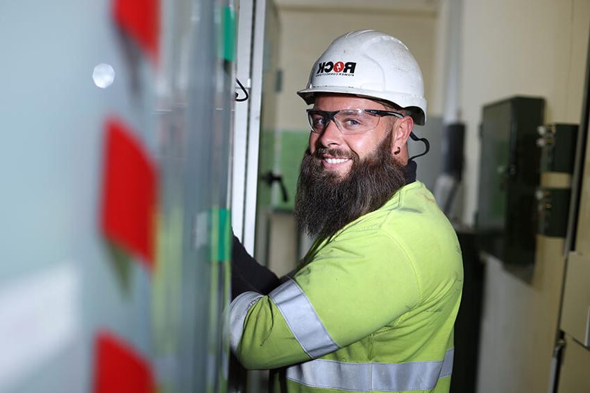 Rock Power Connection male employee, smiling and wearing high vis clothing